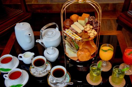 a tray of food on a table with cups of coffee at Tea Queens Bungalow in Hatton