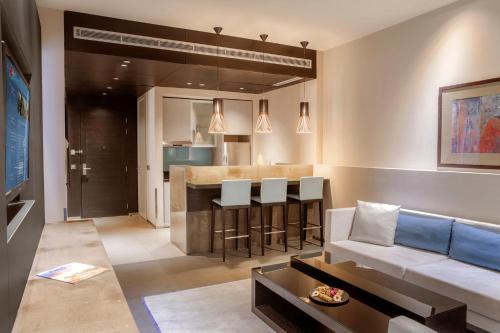 a living room with a couch and a bar at The Abdali Boulevard Hotel in Amman