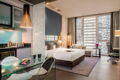 a bedroom with a bed and a living room at The Abdali Boulevard Hotel in Amman