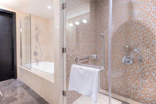 a bathroom with a shower and a sink at The Abdali Boulevard Hotel in Amman