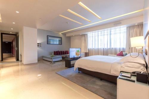 a bedroom with a large bed and a living room at The Abdali Boulevard Hotel in Amman