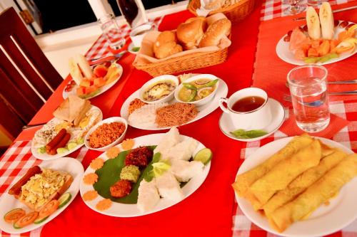 a table with plates of food on a red table cloth at Tea Queens Bungalow in Hatton