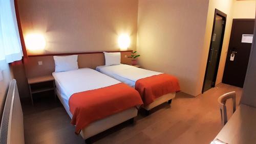 a hotel room with two beds in a room at Hotel Taormina Brussels Airport in Zaventem