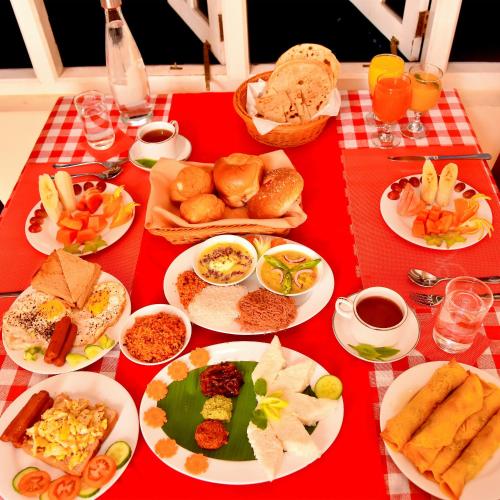 a red table with plates of food on it at Tea Queens Bungalow in Hatton