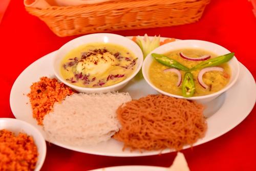 a plate of food with bowls of soup and bread at Tea Queens Bungalow in Hatton