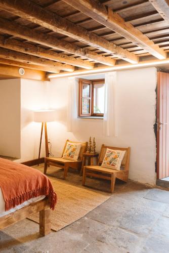 a bedroom with two chairs and a bed and a window at Dreamsea Boutique Experience in Moya