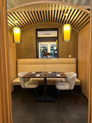 a table and chairs in a restaurant with a mirror at Hotel Taormina Brussels Airport in Zaventem