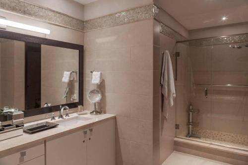 a bathroom with a shower and a sink and a mirror at Just a few minutes walking to the Beach Club in Sabana