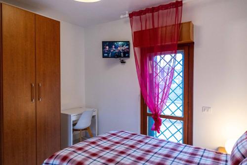 a bedroom with a bed and a window with red curtains at UMA Home in Rome