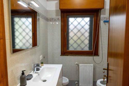 a bathroom with a sink and a toilet and a mirror at UMA Home in Rome