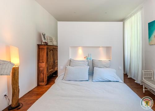 a bedroom with a white bed with two pillows at Un Petit Château in Lauzun