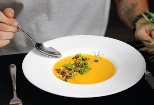 a person eating a bowl of soup with a spoon at Jurajski Kryształ in Zaborze