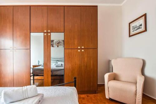 a bedroom with a bed and a chair and a cabinet at Firenze Bellariva Riverside Stay in Florence