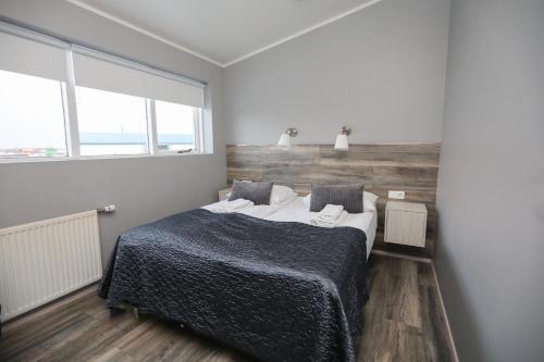 a bedroom with a bed and a large window at Skýjaborg Apartments in Höfn