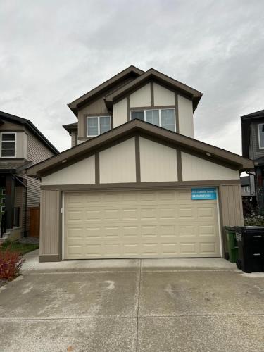 a house with a garage door in a driveway at Bedroom SW Edmonton HWY 2 near YEG in Edmonton