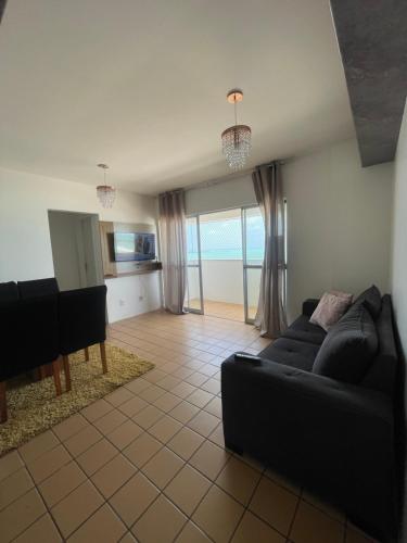 a living room with a couch and a piano at Apartamento Beira Mar in Maceió