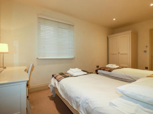 a bedroom with two beds and a window at Blue Horizon in Port Isaac