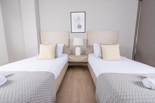 two beds sitting next to each other in a room at Immense appartement 6pièces au Golf in El Mouradia