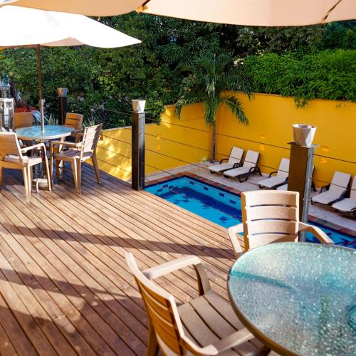 a deck with a table and chairs and a pool at Curazao Hotel -Centro Histórico- in Santa Fe de Antioquia