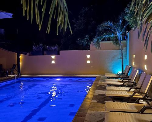 a swimming pool at night with lounge chairs around it at Curazao Hotel -Centro Histórico- in Santa Fe de Antioquia