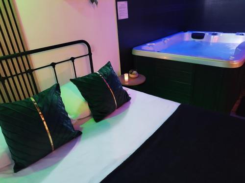 - une chambre avec un lit et une baignoire dans l'établissement Autrement Spa, à Avelin