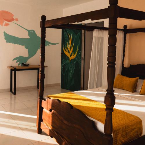 a bedroom with a wooden bed with a dragon painted on the wall at Curazao Hotel -Centro Histórico- in Santa Fe de Antioquia