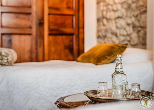 a tray with a bottle and glasses on a bed at Un Petit Château in Lauzun