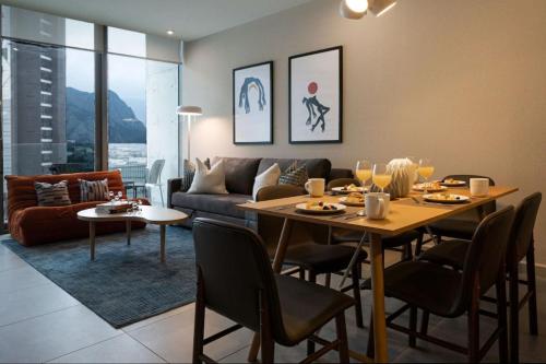 a living room with a table and a couch at Modern Apartments with Pool and Mountain views in Monterrey