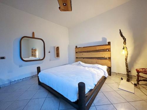 a bedroom with a bed and a mirror on the wall at La casa in campagna in Cascina Grossa