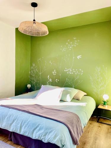 - une chambre dotée d'un lit avec un mur vert dans l'établissement Gite La Merlandie, à Montazeau