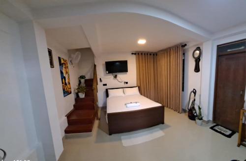 une petite chambre avec un lit et une télévision dans l'établissement Migela Restaurant & Rooms, à Walliwala East