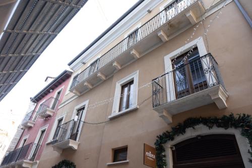 a building with windows and balconies on a street at San Massimo Apartment - Piazza Duomo L'Aquila in LʼAquila