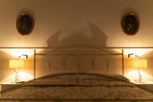 a bedroom with a bed with two lamps on it at San Massimo Apartment - Piazza Duomo L'Aquila in LʼAquila
