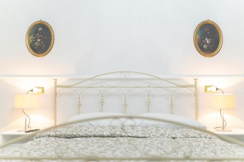 a bedroom with a white bed with two lamps at San Massimo Apartment - Piazza Duomo L'Aquila in LʼAquila
