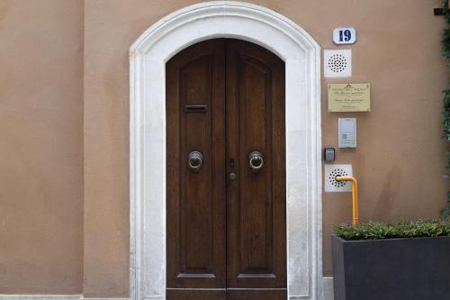 a wooden door with an archway in front of a building at San Massimo Apartment - Piazza Duomo L'Aquila in LʼAquila