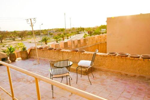 a patio with two chairs and a table on a balcony at Dar Chamss in Taroudant