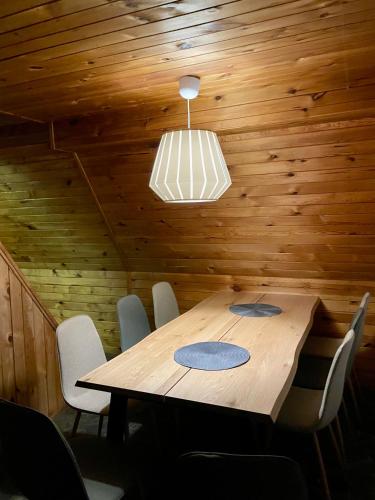 Un comedor con mesa y sillas de madera. en Chata pod Černou horou, en Rudník