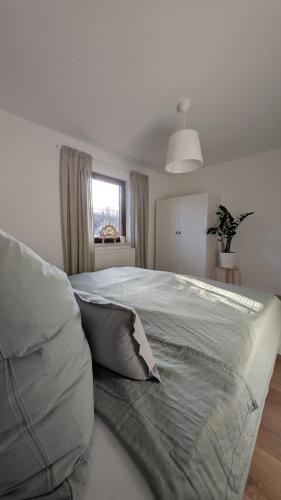 a white bedroom with a large bed with pillows at Ferienwohnung Pöhlwasserblick in Pöhla