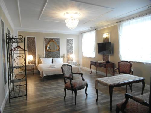Habitación de hotel con cama, mesa y sillas en B&B Lawendowy Pałacyk, en Błonie