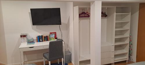 a room with a desk and a television on a wall at Ferienwohnung-Vetter in Bodelshausen