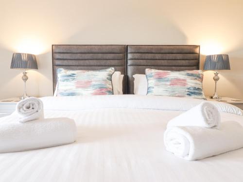 two beds with towels on them in a bedroom at Aelfor in Harlech