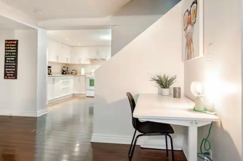 a white kitchen with a table and a chair at 2 bedroom apartment-2 free parking -14 min to Pearson airport in Mississauga