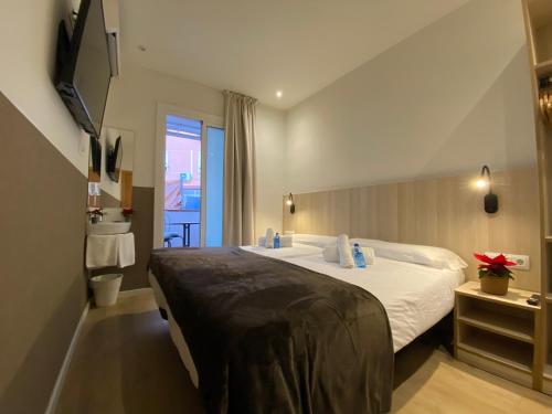 a hotel room with a large bed and a window at Hostal BESTPRICE Barcelona Stadium in Barcelona