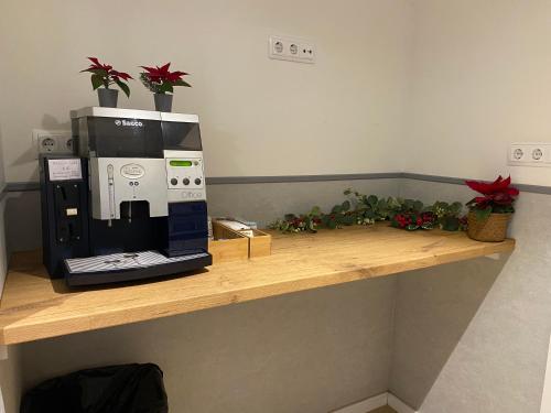 a coffee maker on a wooden shelf with potted plants at Hostal BESTPRICE Barcelona Stadium in Barcelona
