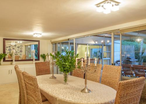 a dining room with a table with chairs and a tableablish at TarongaVilla in Constantia