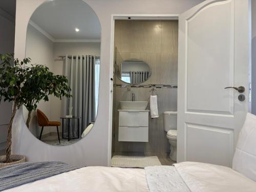 a bathroom with a mirror and a sink and a toilet at Modern 3 bedroom Urban Getaway in Cape Town