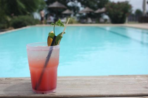 a drink sitting on a table next to a pool at Agriturismo La Rinaldina in Faenza