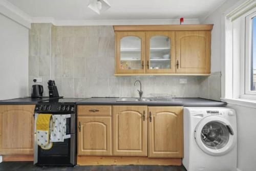 a kitchen with a washer and a washing machine at BridgeCity Hidden Gem in the heart of Falkirk Roughland house Stirlingshire in Carron