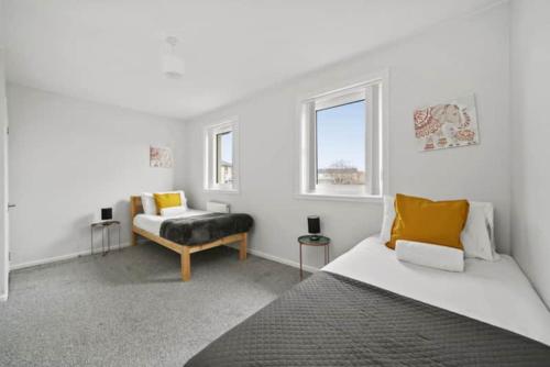 a white room with a bed and a chair at BridgeCity Hidden Gem in the heart of Falkirk Roughland house Stirlingshire in Carron