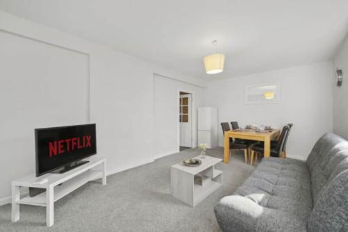 a living room with a couch and a tv at BridgeCity Hidden Gem in the heart of Falkirk Roughland house Stirlingshire in Carron